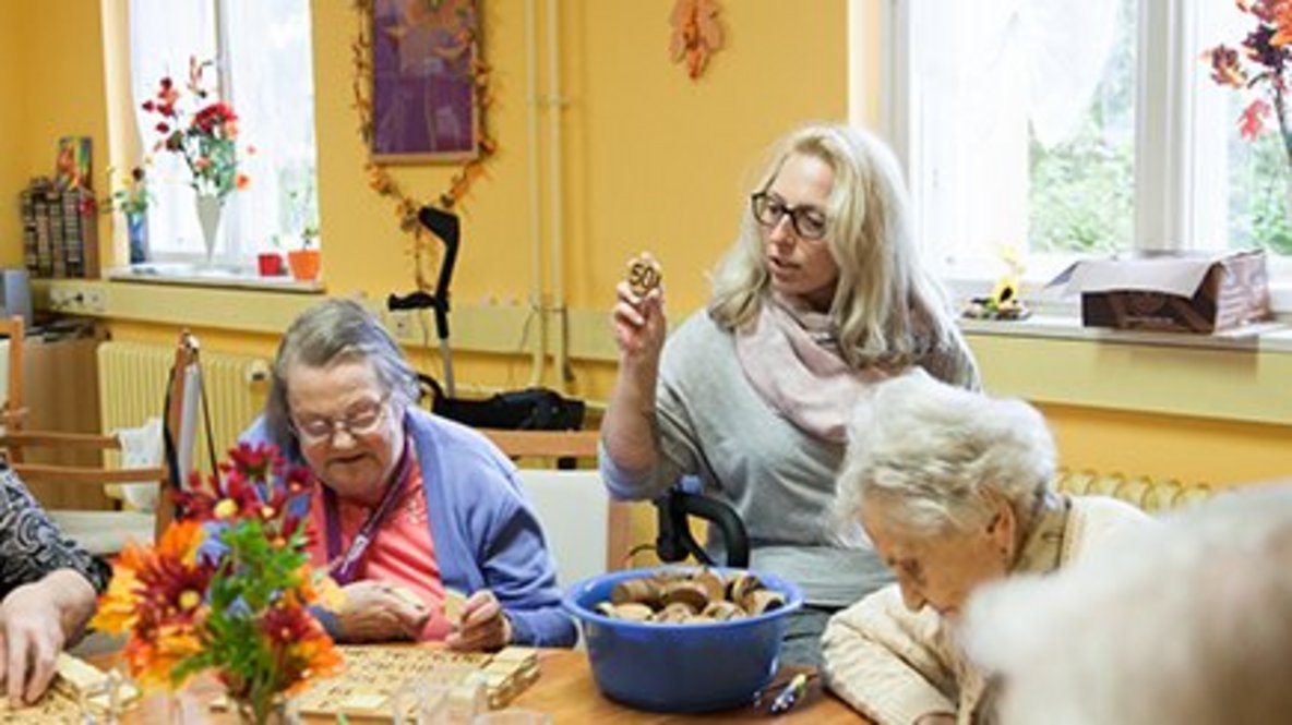 Mitarbeiterin und zwei Gäste beim Bingo